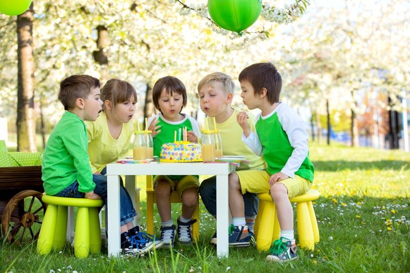 Kinder pusten Kerzen auf Torte aus